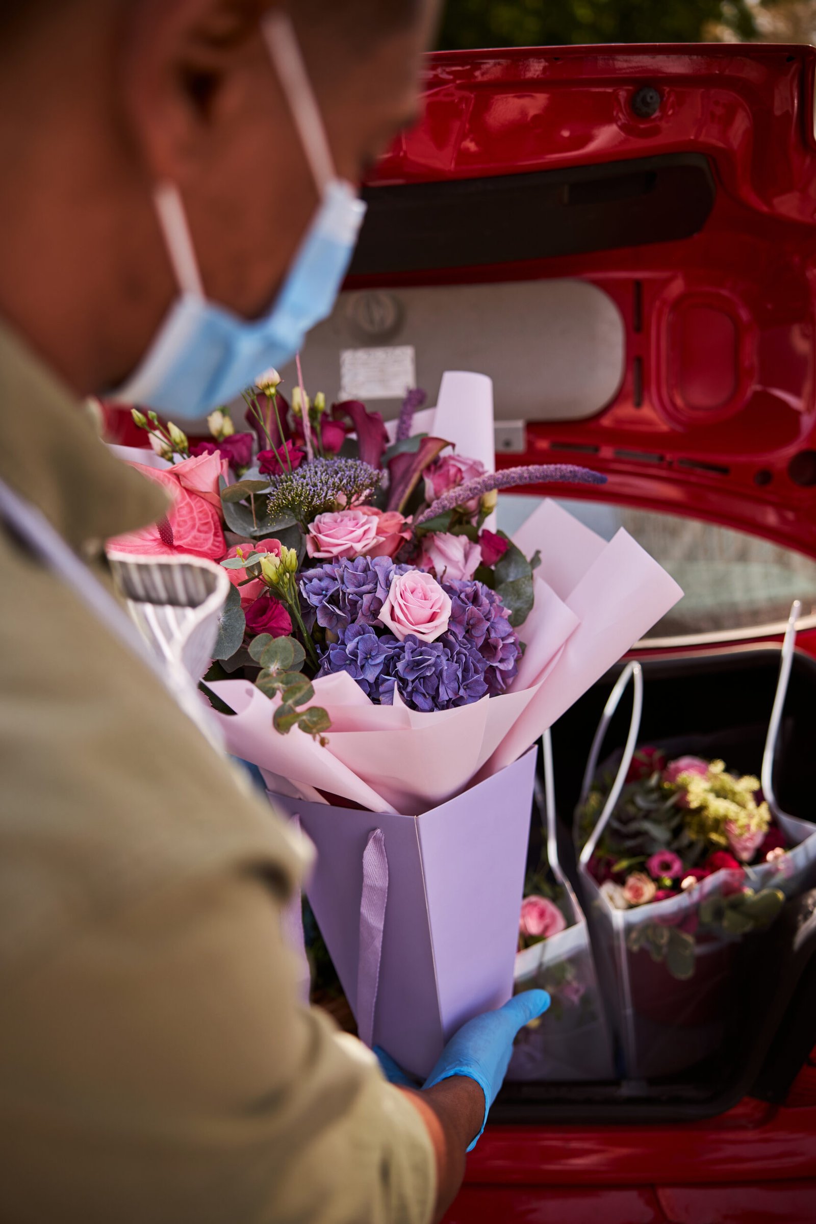 Floral specialist loading a posy into a luggage boot